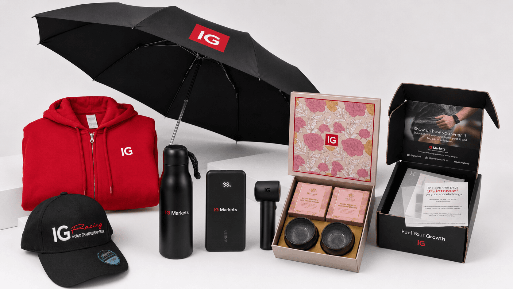 IG Markets merchandise including a branded hoodie, cap, umbrella, drinkware and gift packaging